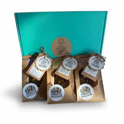 Pack Cachorro Pompón con caja turquesa detrás de  3 bolsitas de snacks naturales con etiquetas colgantes redondas y cordel de yute de Woof Natural, etiqueta central del pack visible en la tapa